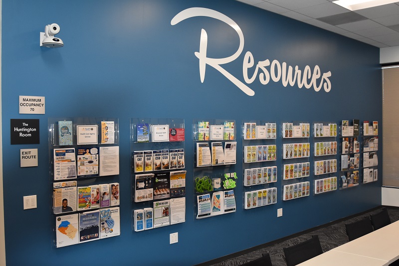 Wall labeled "Resources" with many hanging informational pamphlets 