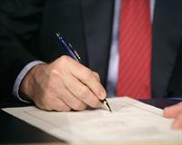 photo: person signing a document