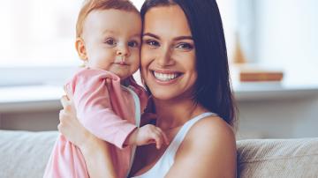 Young Caucasian mother holding up her baby girl