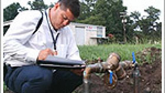 Man inspecting underground pipe