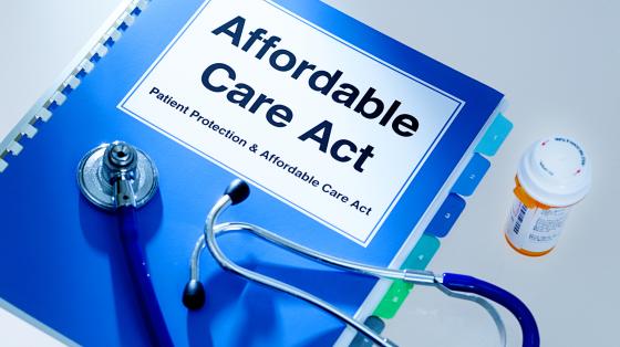 binder titled Affordable Care Act and stethoscope with prescription pills