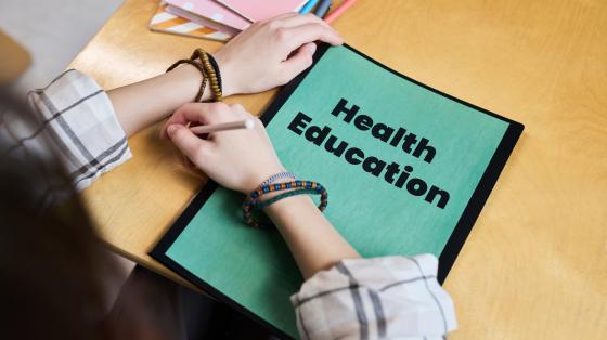 woman looking at a folder with "health education" written on it