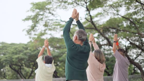 older adults doing yoga outdoors