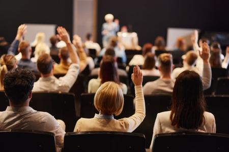 Back of People Meeting, Hands Raised