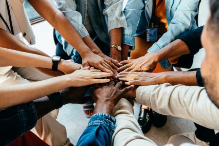 hands of several people coming together